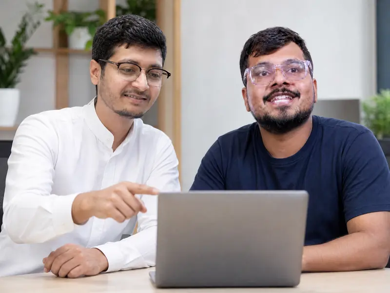 Deep Shah and Darsh Chandura reviewing a website together on a laptop